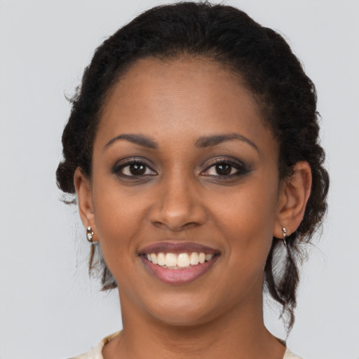 Joyful black young-adult female with medium  brown hair and brown eyes