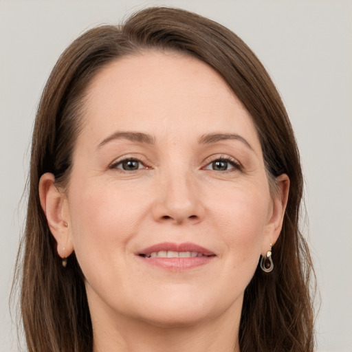 Joyful white adult female with long  brown hair and grey eyes