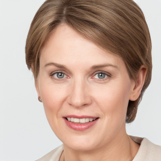 Joyful white adult female with medium  brown hair and grey eyes