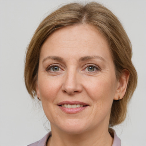 Joyful white adult female with medium  brown hair and grey eyes