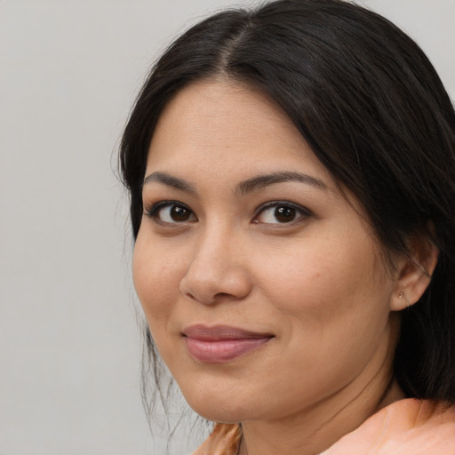 Joyful latino adult female with medium  brown hair and brown eyes