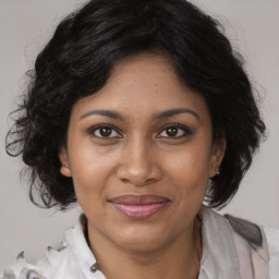 Joyful black adult female with medium  brown hair and brown eyes