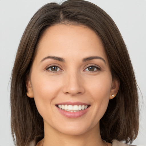 Joyful white young-adult female with long  brown hair and brown eyes