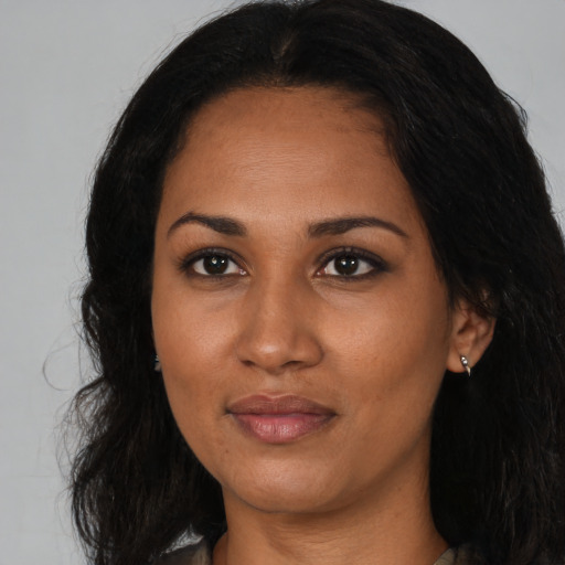 Joyful black young-adult female with long  brown hair and brown eyes