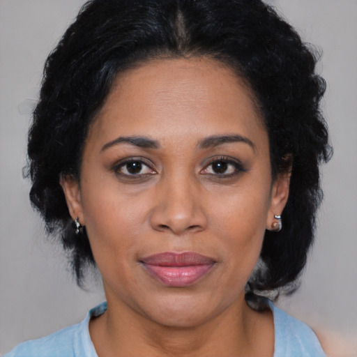 Joyful latino adult female with medium  brown hair and brown eyes