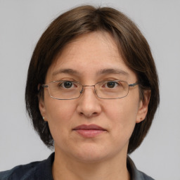 Joyful white adult female with medium  brown hair and grey eyes