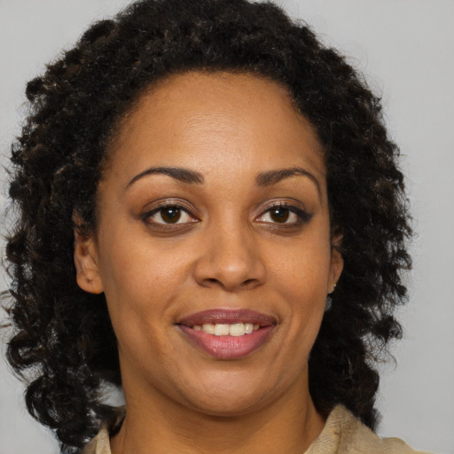 Joyful black adult female with medium  brown hair and brown eyes