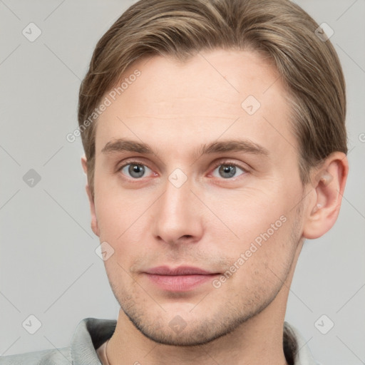 Joyful white young-adult male with short  brown hair and grey eyes