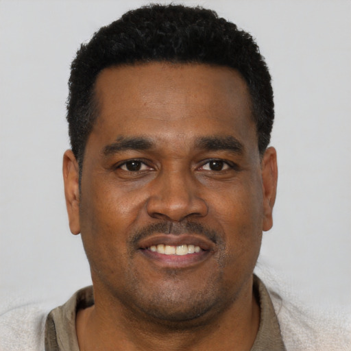 Joyful black young-adult male with short  black hair and brown eyes