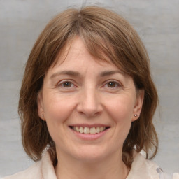 Joyful white adult female with medium  brown hair and grey eyes