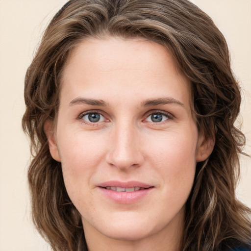 Joyful white young-adult female with long  brown hair and blue eyes