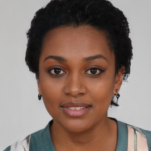 Joyful black young-adult female with short  black hair and brown eyes