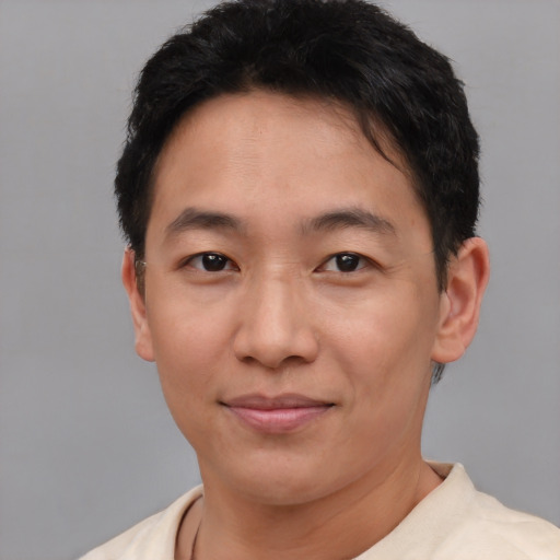 Joyful asian adult male with short  brown hair and brown eyes