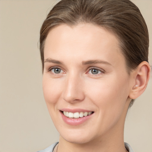 Joyful white young-adult female with short  brown hair and grey eyes