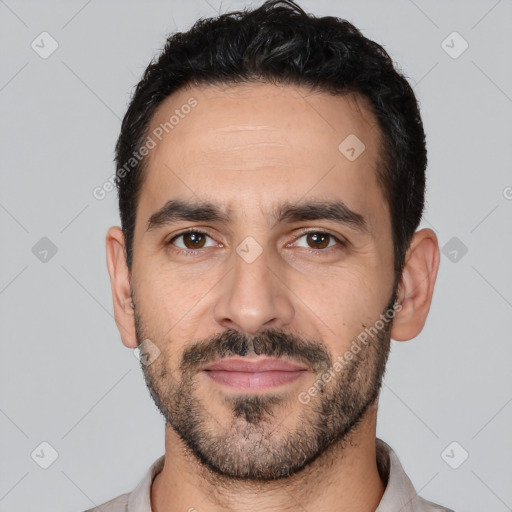 Joyful white young-adult male with short  black hair and brown eyes