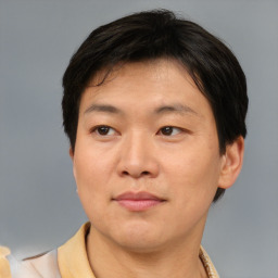 Joyful asian adult male with short  brown hair and brown eyes