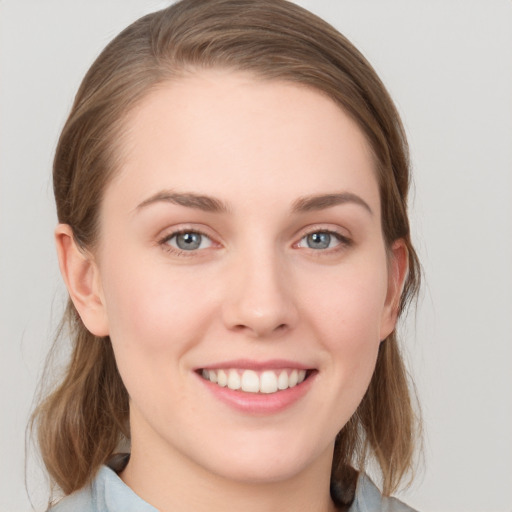 Joyful white young-adult female with medium  brown hair and blue eyes