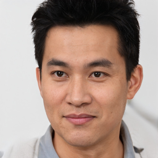 Joyful asian adult male with short  brown hair and brown eyes