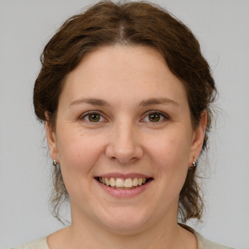 Joyful white young-adult female with medium  brown hair and green eyes