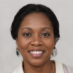 Joyful black adult female with medium  brown hair and brown eyes