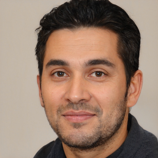 Joyful white young-adult male with short  black hair and brown eyes