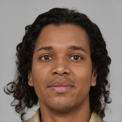 Joyful black young-adult male with medium  brown hair and brown eyes