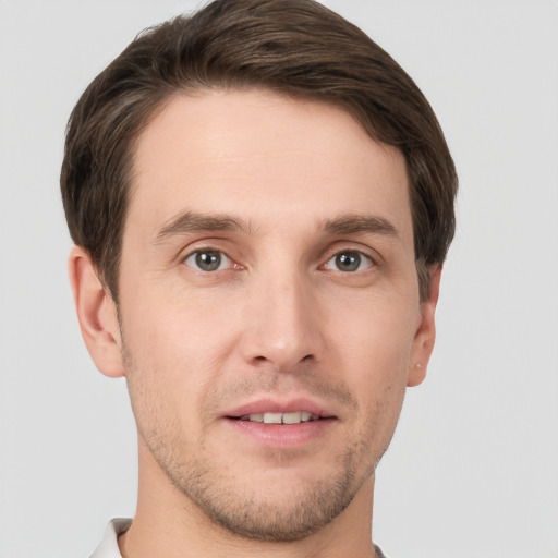 Joyful white young-adult male with short  brown hair and grey eyes