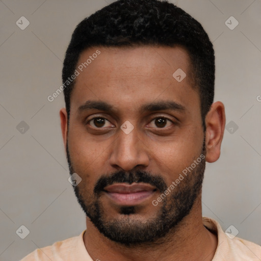Joyful black young-adult male with short  black hair and brown eyes