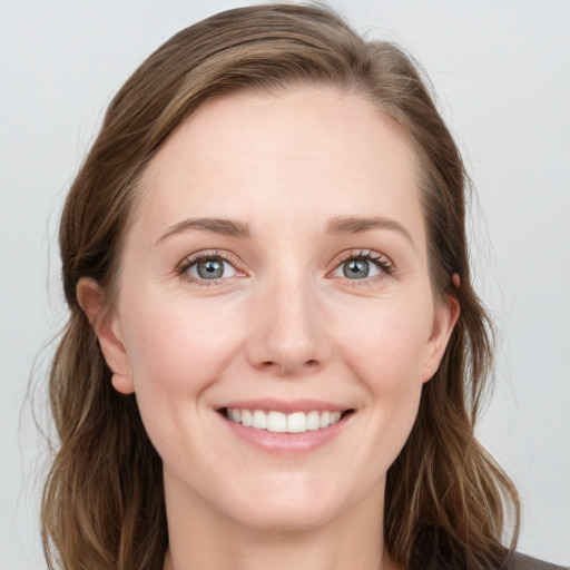 Joyful white young-adult female with long  brown hair and blue eyes