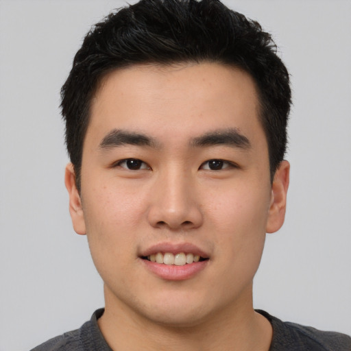 Joyful asian young-adult male with short  black hair and brown eyes