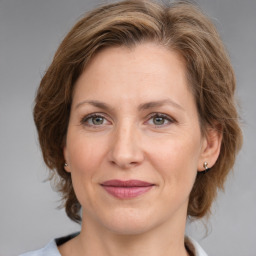 Joyful white adult female with medium  brown hair and grey eyes