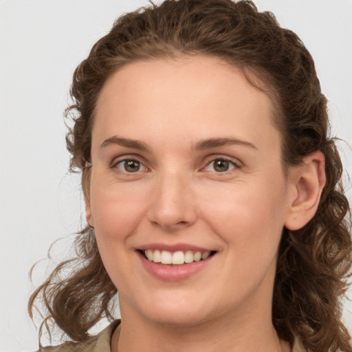 Joyful white young-adult female with medium  brown hair and green eyes