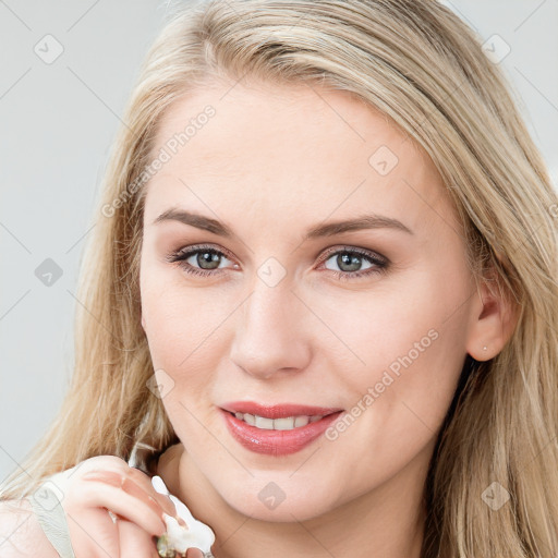 Joyful white young-adult female with long  brown hair and blue eyes