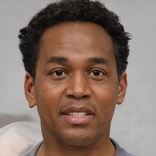 Joyful black adult male with short  brown hair and brown eyes