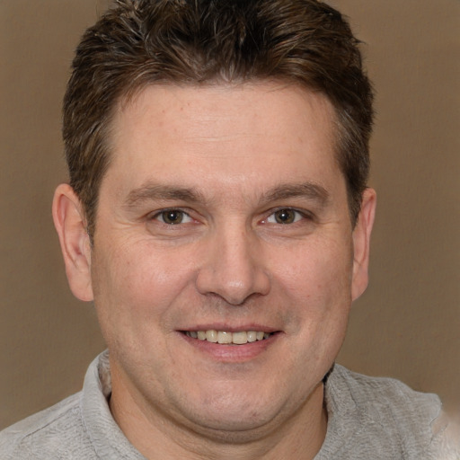 Joyful white adult male with short  brown hair and brown eyes