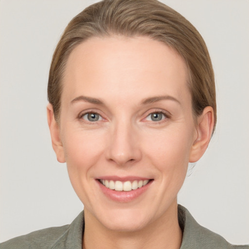 Joyful white young-adult female with short  brown hair and grey eyes