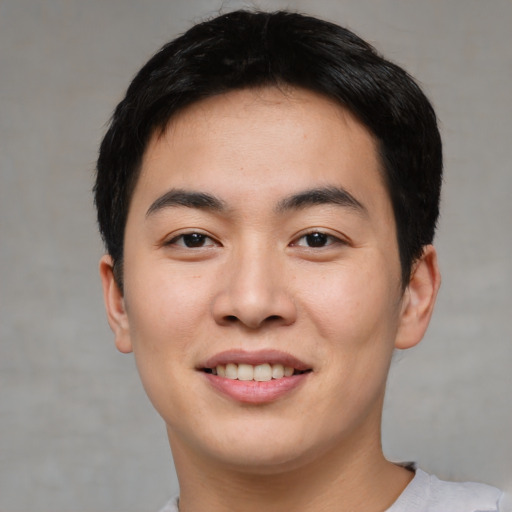 Joyful asian young-adult male with short  black hair and brown eyes