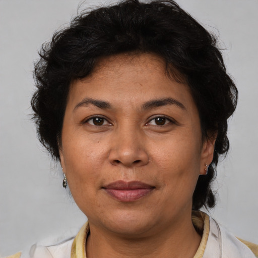 Joyful latino adult female with medium  brown hair and brown eyes