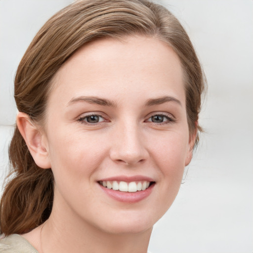 Joyful white young-adult female with medium  brown hair and blue eyes