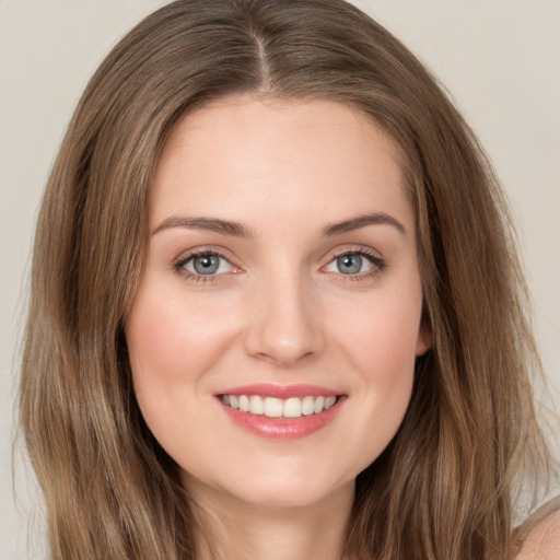 Joyful white young-adult female with long  brown hair and green eyes