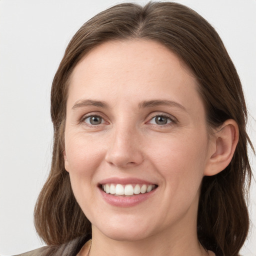 Joyful white young-adult female with medium  brown hair and grey eyes