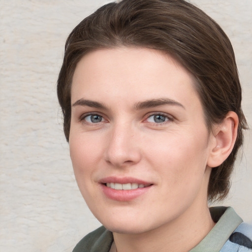 Joyful white young-adult female with medium  brown hair and blue eyes