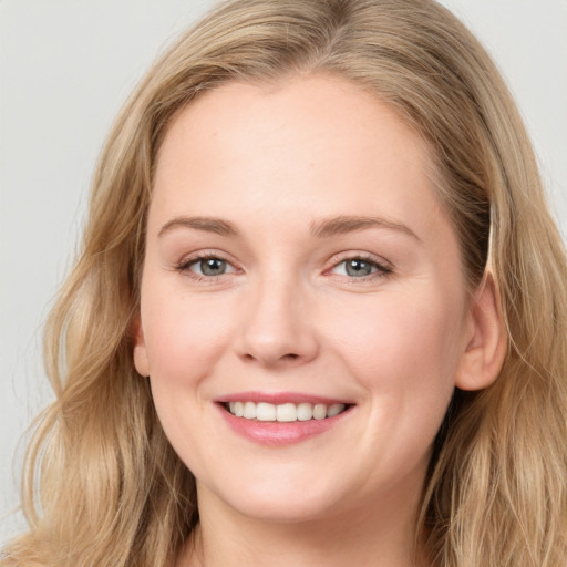 Joyful white young-adult female with long  brown hair and blue eyes