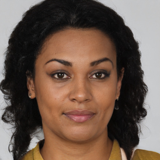 Joyful black young-adult female with long  brown hair and brown eyes