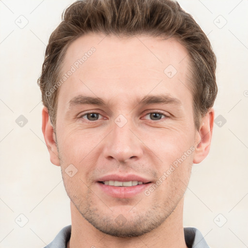 Joyful white young-adult male with short  brown hair and grey eyes