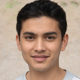 Joyful latino young-adult male with short  brown hair and brown eyes