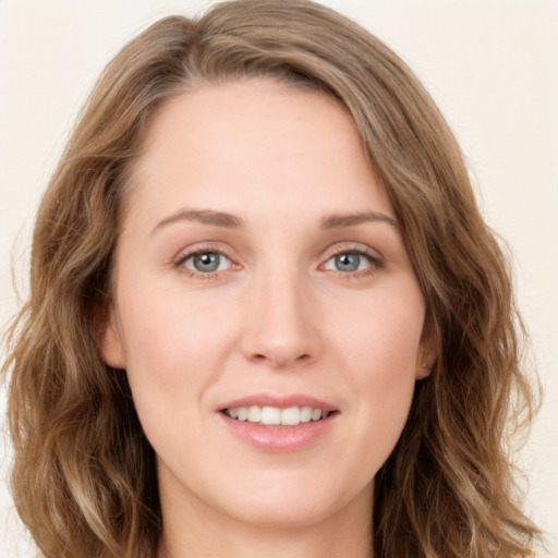 Joyful white young-adult female with long  brown hair and blue eyes