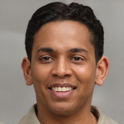 Joyful latino young-adult male with short  brown hair and brown eyes