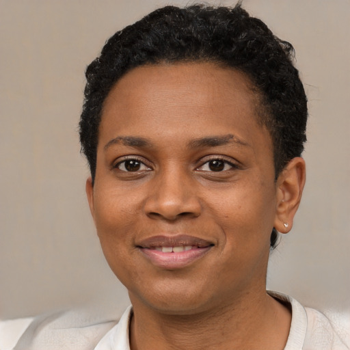 Joyful black young-adult female with short  black hair and brown eyes