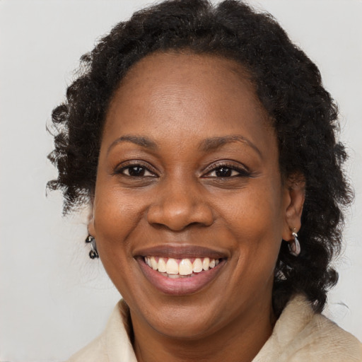 Joyful black adult female with medium  brown hair and brown eyes